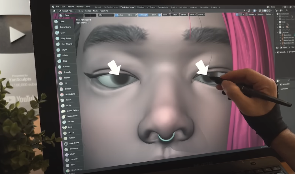 Hand using pen and touchscreen to create a 3D character