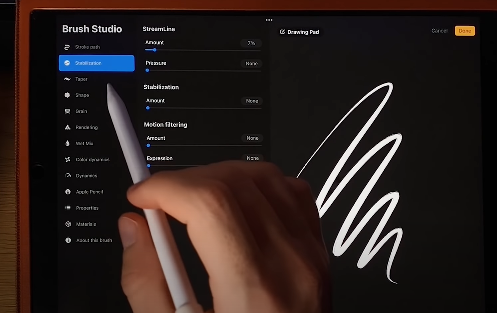 An image of an iPad with a hand using a pen to edit brush tools
